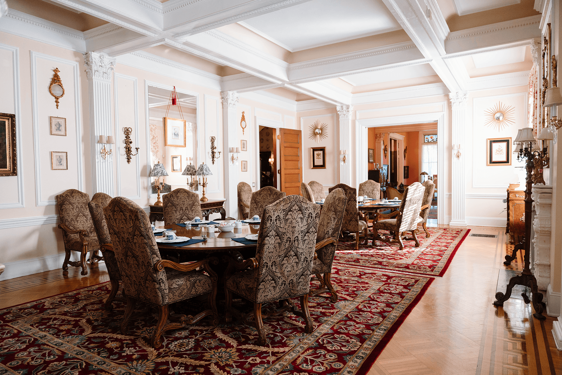 Elegant dining room featuring ornate furniture, a patterned rug, and a warm, inviting atmosphere.
